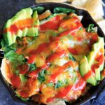 Oven-baked spinach nachos in a cast iron skillet. A great party snack, meal for 2 (or 1!) that has a little extra nutrition with greens.