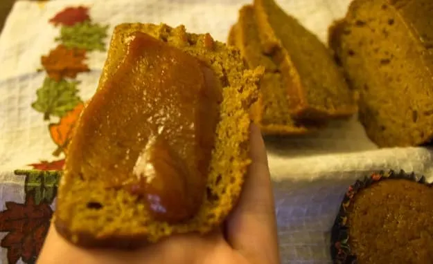 sliced applesauce pumpkin bread with some pumpkin butter spread on top