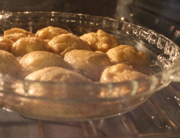 glazed honey rolls baking in clear dish in oven