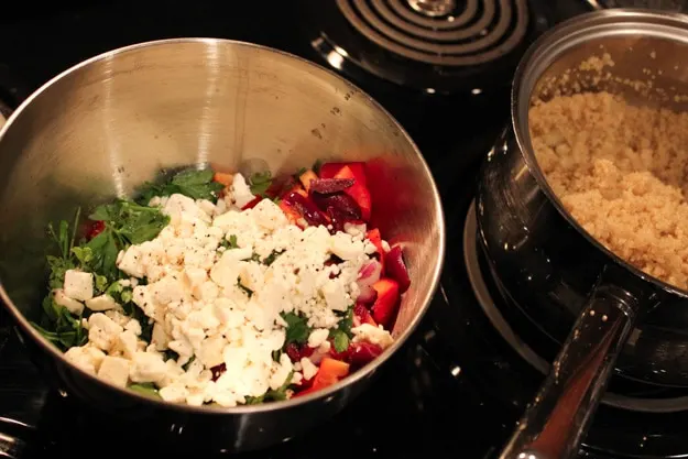 prepping Greek Quinoa Salad in bowl