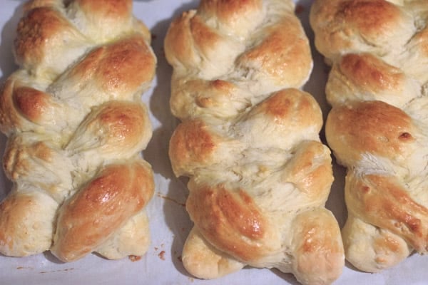 3 braided challah bread loaves after baking