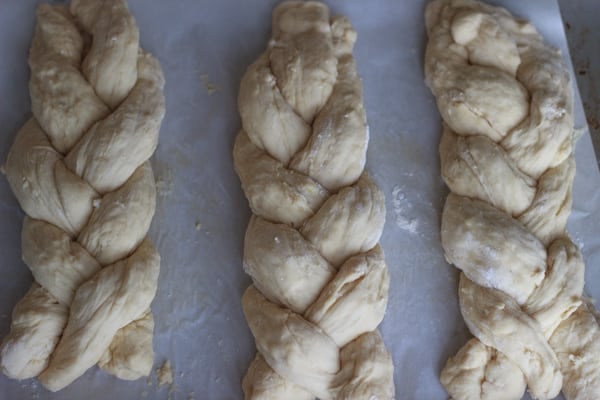 three braided challah bread loaves before baking