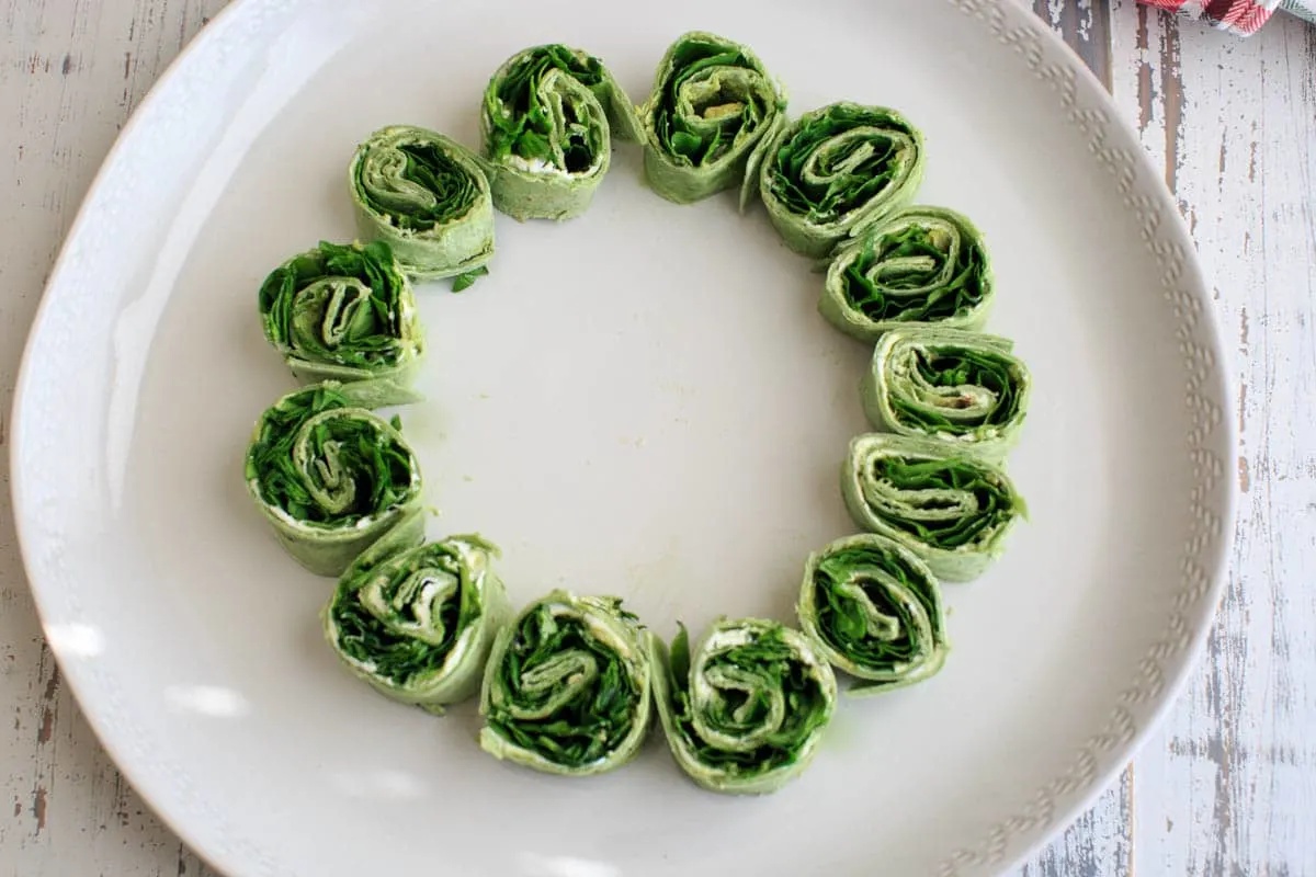 Arranging the Christmas tree pita pinwheel on white plate