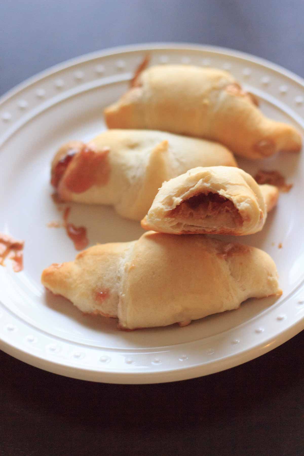 Peanut butter and jelly wraps on white plate with bite taken out