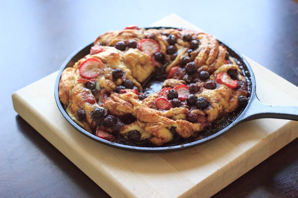 baked berry bread on skillet on top of cutting board