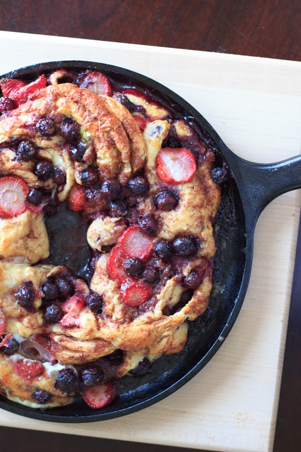 Berries stuffed inside delicious cinnamon swirl bread on cast iron skillet