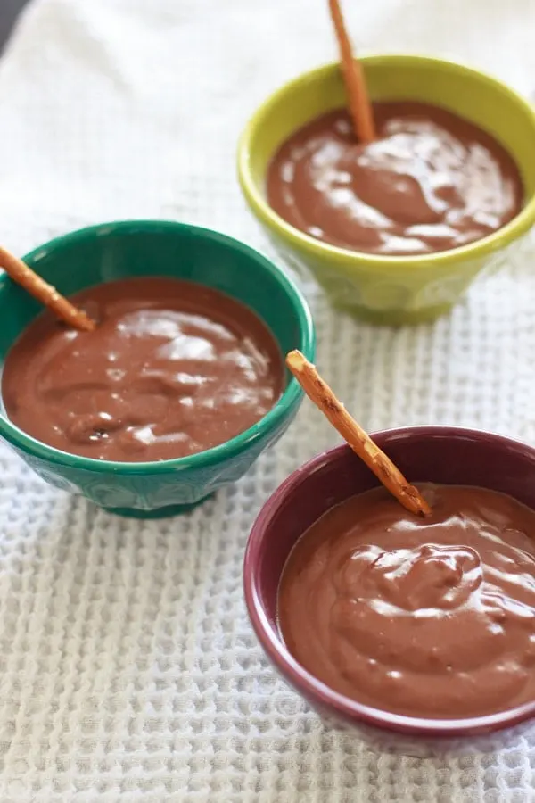 Nutella pudding in 3 dessert bowls with pretzel sticks