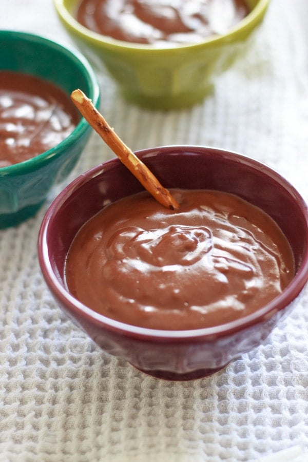 Nutella pudding in purple dessert bowl with pretzel stick