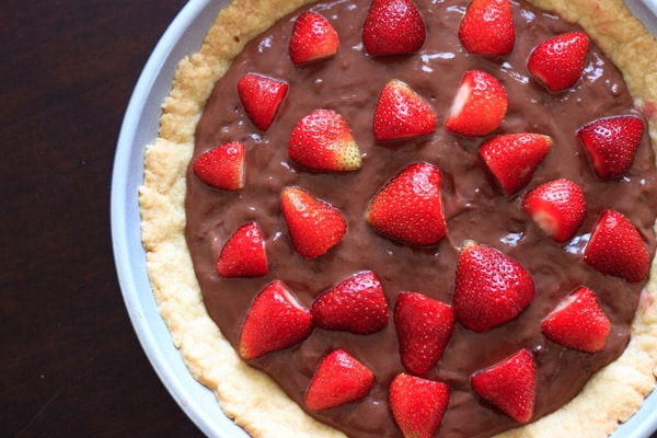 nutella pudding tart with strawberries on top, in baking pan