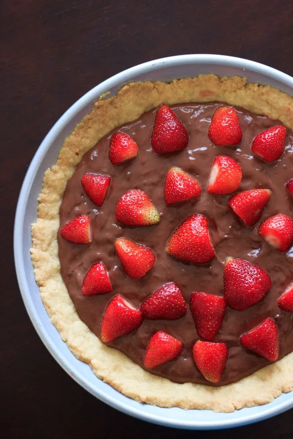 nutella pudding tart with strawberries on top, in baking pan