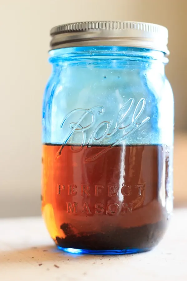 homemade vanilla extract in blue mason jar after letting sit for 2 weeks