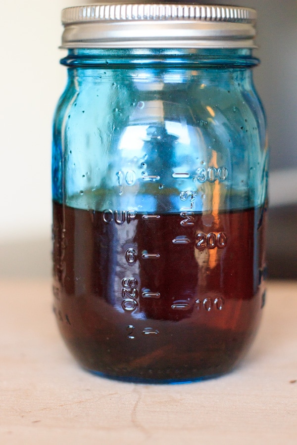 homemade vanilla extract in blue mason jar after letting sit for 1 month