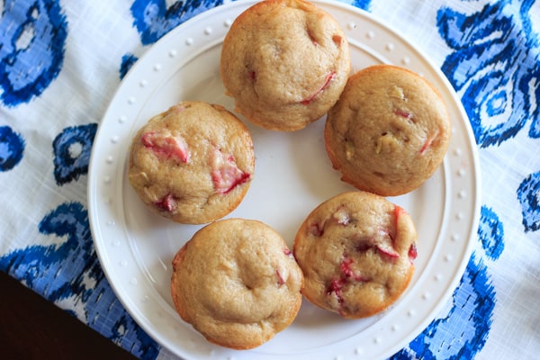 5 Strawberry rhubarb muffins arranged on white plate