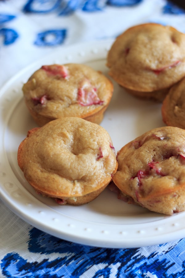 Strawberry rhubarb muffins arranged on white plate