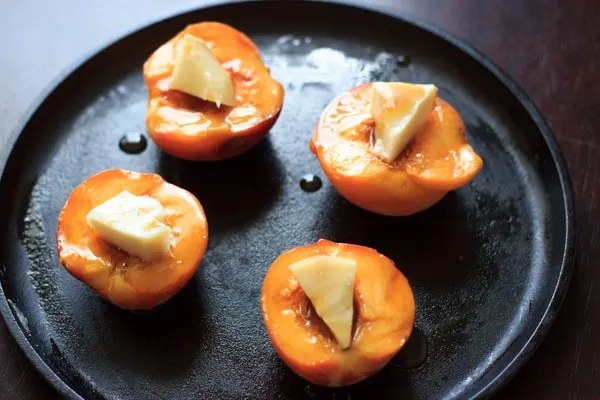 fresh peaches and brie topped with hoey on skillet before baking