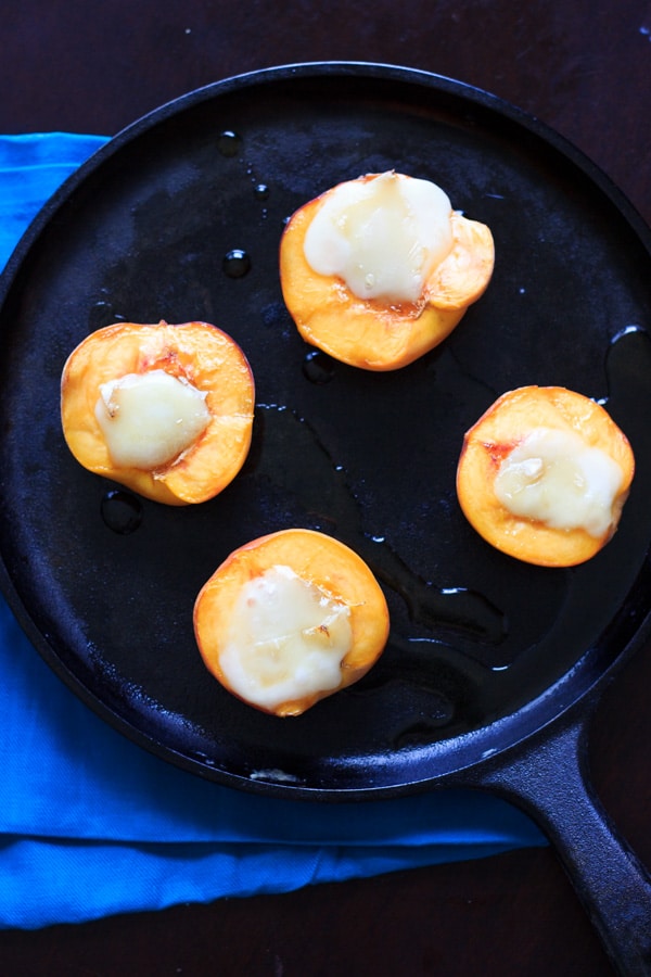 baked peaches with brie and honey on skillet