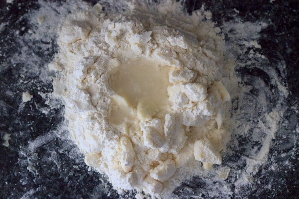 flour mound with water and chunks of butter mixed in