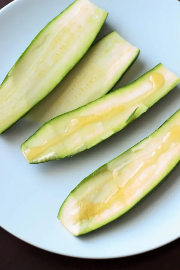 two zucchinis cut in half, some with honey on it