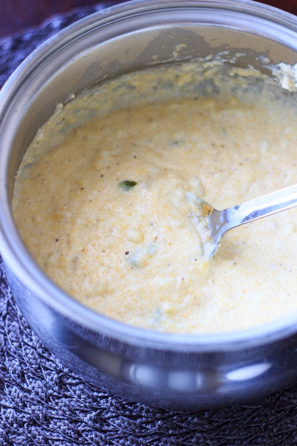 spicy grits being stirred in stock pot