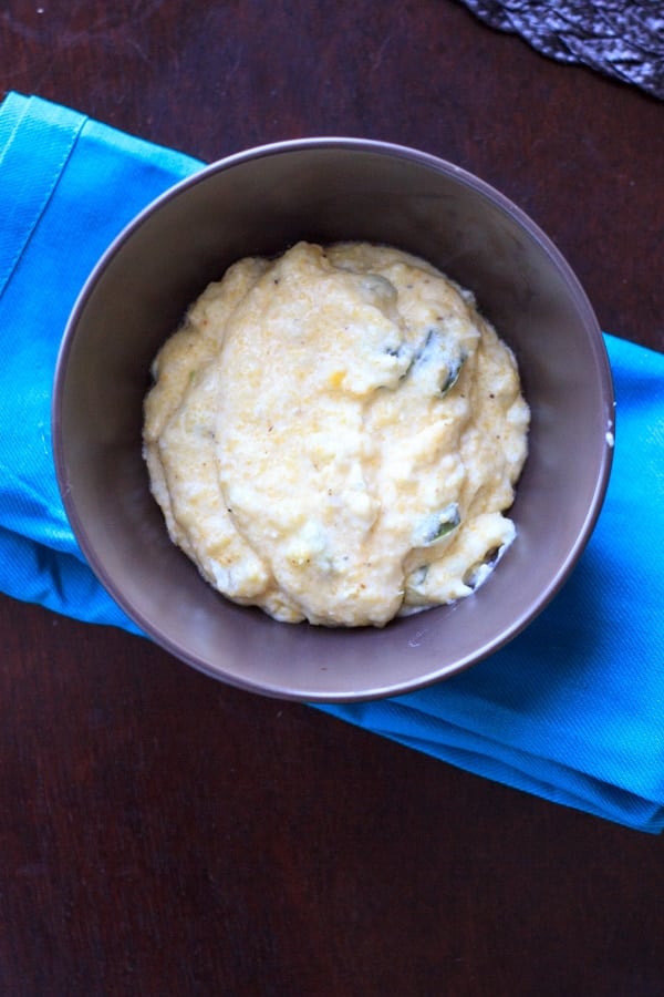 brown bowl with spicy grits on top of blue folded napkin