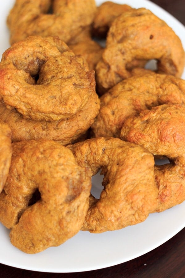 Pumpkin bagels stacked on white plate