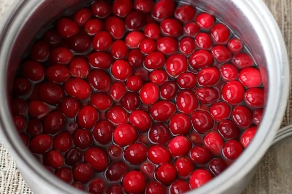 cranberries soaking in simple syrup in pot