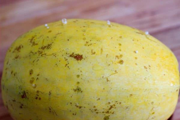 spaghetti squash with holes poked in and bubbles coming out from cooking