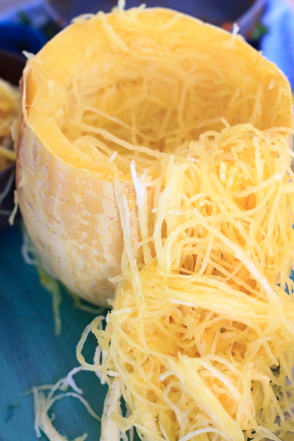 showing long spaghetti squash strands coming out of cut squash