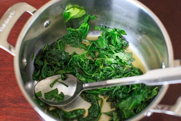 fresh baby spinach leaves after sautéed down in pot.