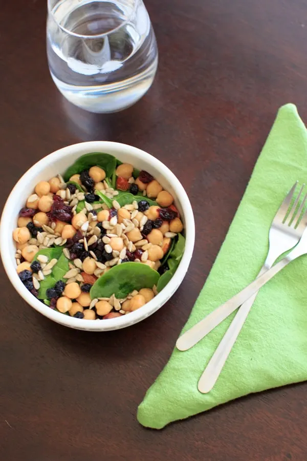 Spinach Chickpea Salad - a bowl of deliciousness! Protein, veggies, fruit, seeds, and nuts = flavor that will make you say goodbye to your normal boring salad.