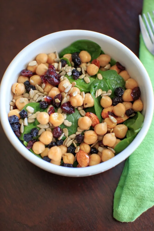 Spinach Chickpea Salad - a bowl of deliciousness! Protein, veggies, fruit, seeds, and nuts = flavor that will make you say goodbye to your normal boring salad.