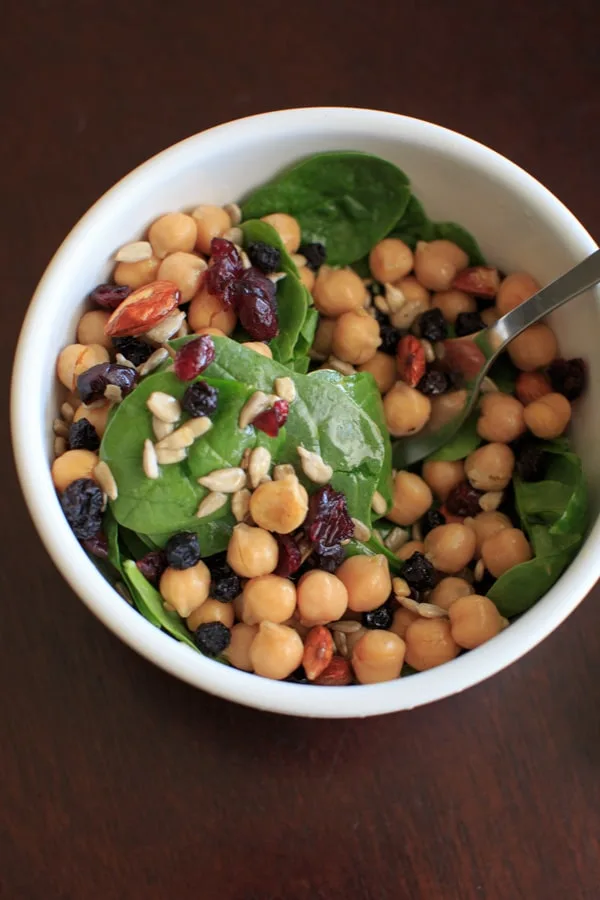 Spinach Chickpea Salad - a bowl of deliciousness! Protein, veggies, fruit, seeds, and nuts = flavor that will make you say goodbye to your normal boring salad.