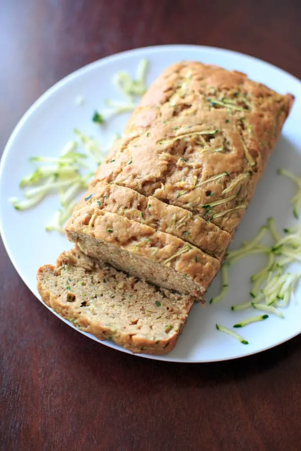Skinnier Zucchini Bread loaf sliced, on white plate