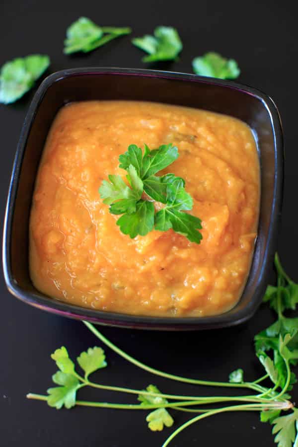 Sweet Potato and Apple Soup in bowl topped vwith fresh parsley