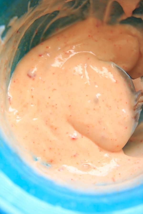 close up of skinny bang bang sauce stirring in bowl with spoon