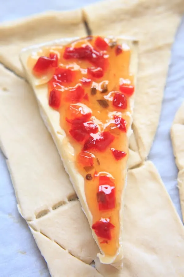 Indulge a little with this Baked Brie cheese with Sweet Hot Pepper Jelly and Pear. Hot and sweet, creamy with a little crunch and a whole lot of deliciousness. Served as an appetizer or dessert, it is sure to be a crowd pleaser.