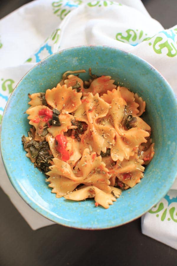 one serving of vegetable bow tie pasta in blue bowl