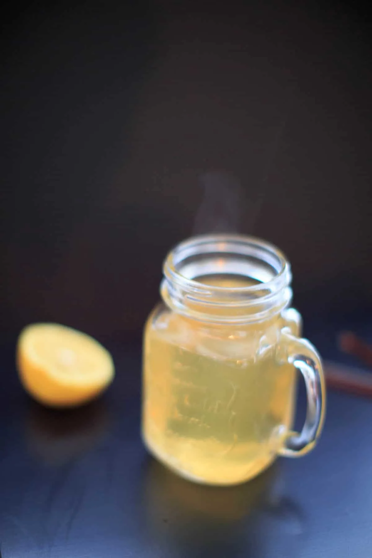 Fireball Hot Toddy in a clear mason jar next to half a lemon