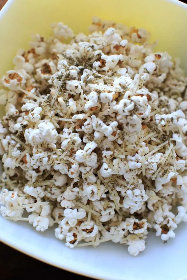 Pizza popcorn is a perfect snack for movie night that's still pretty healthy and full of flavor with dried herbs and parmesan cheese.