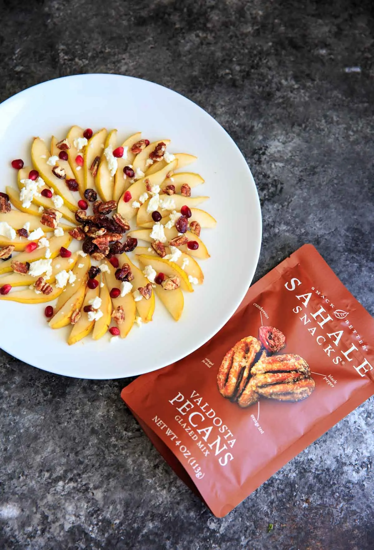 Sweet and savory pear nachos with glazes pecans, chevre cheese, pomegranate seeds and balsamic. A unique snack or dessert!