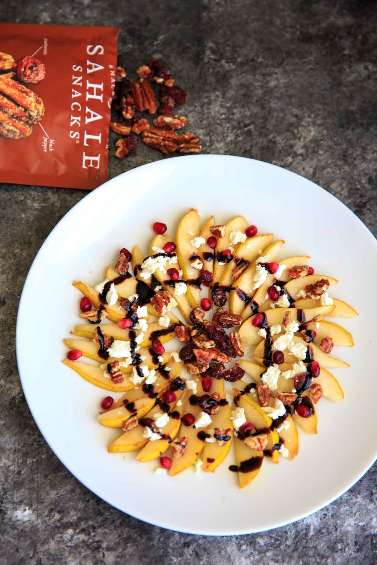 Sweet and savory pear nachos with glazes pecans, chevre cheese, pomegranate seeds and balsamic. A unique snack or dessert!