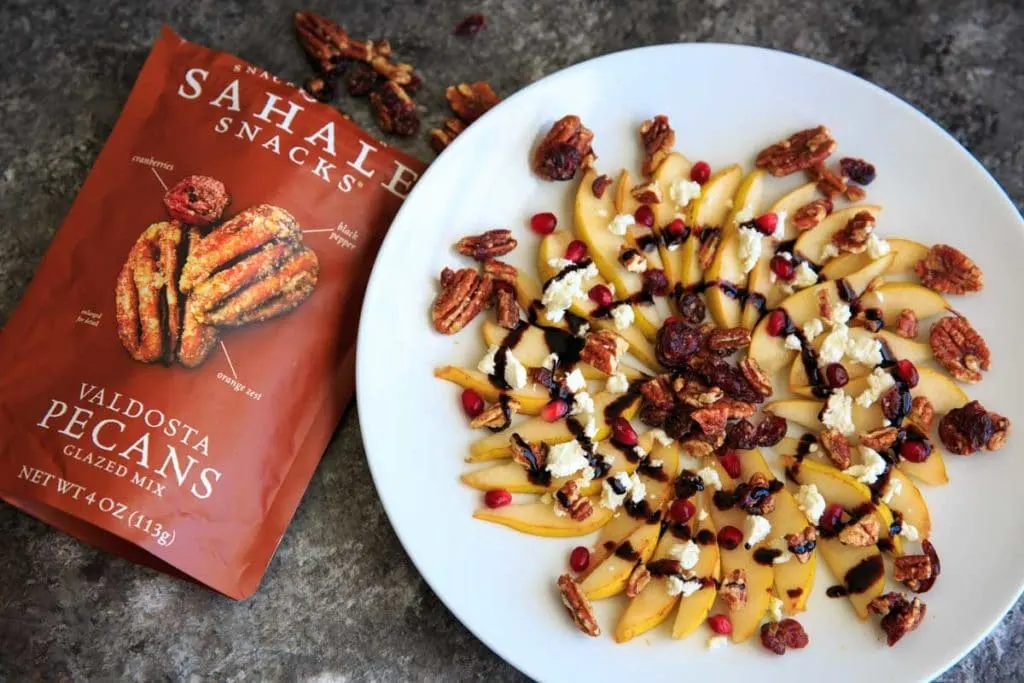 Sweet and savory pear nachos with glazes pecans, chevre cheese, pomegranate seeds and balsamic. A unique snack or dessert!