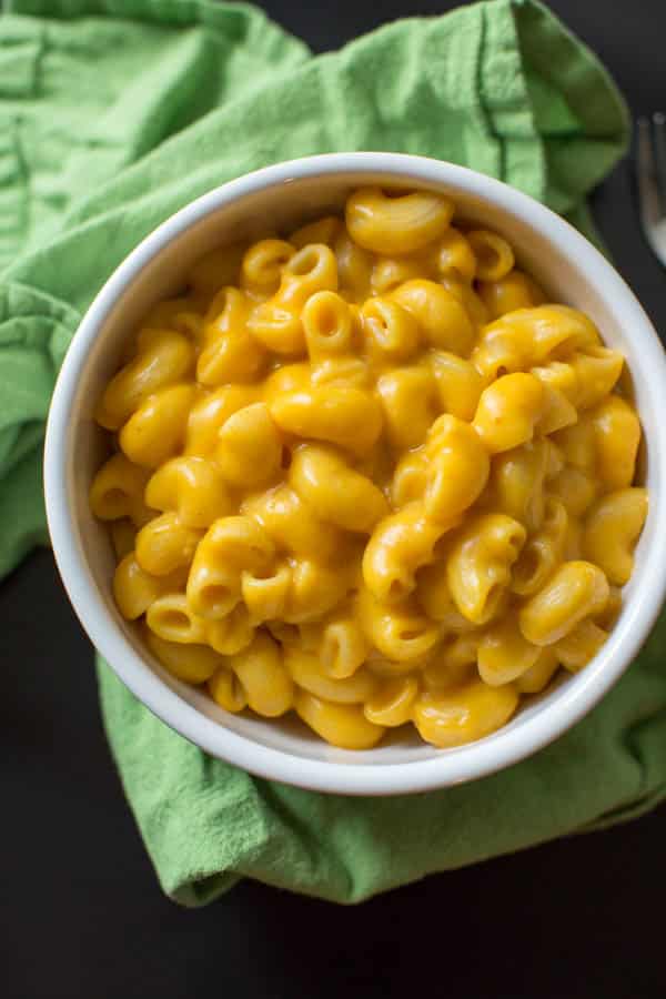 Cheddar Pumpkin Mac and Cheese in white bowl with green napkin