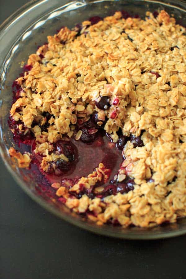 Blueberry crisp crumble with one serving taken out of dish