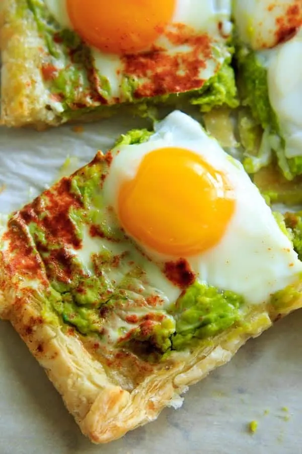 close up of baked egg on top of avocado puff pastry square