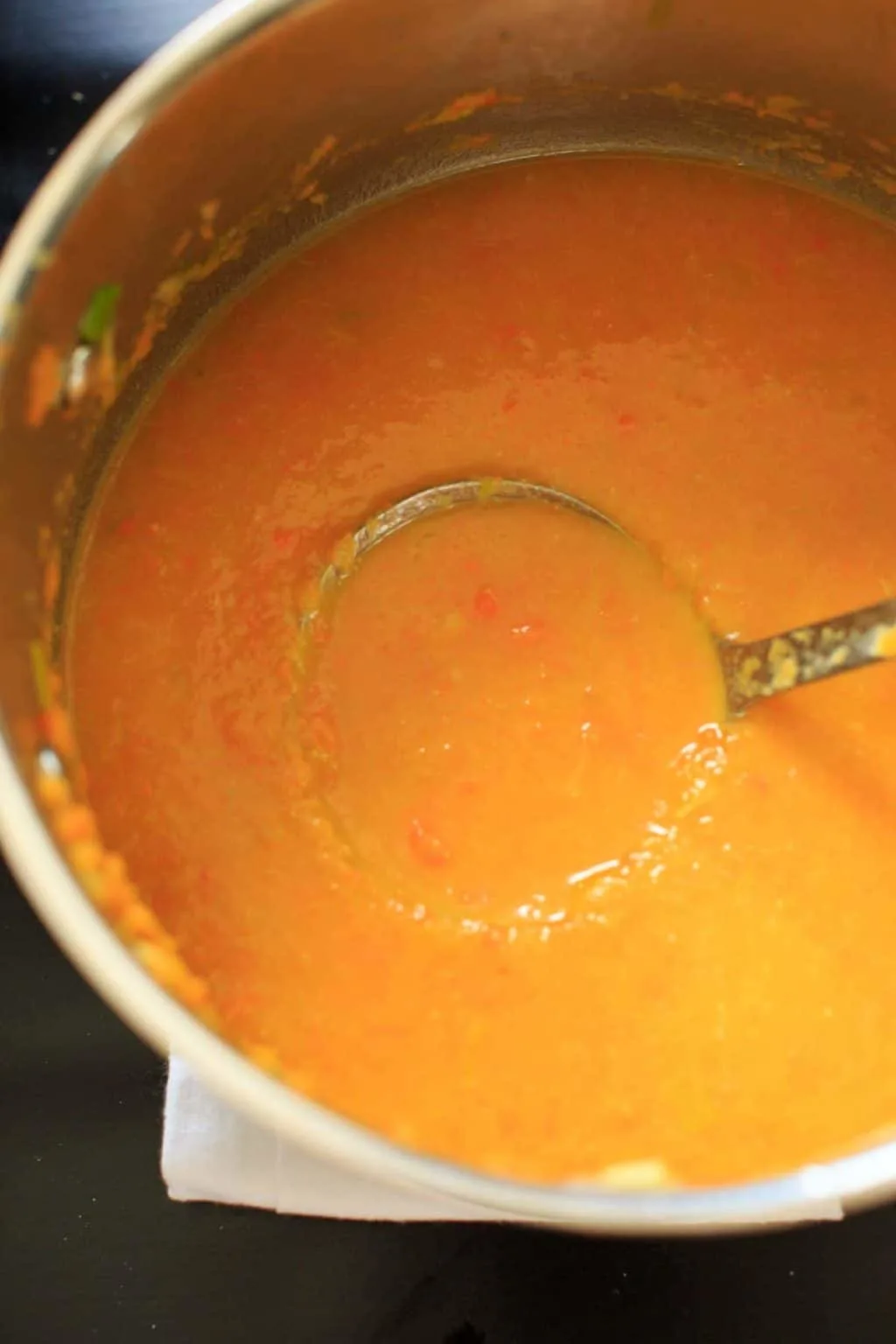 taking a spoonful of carrot leek soup from pot