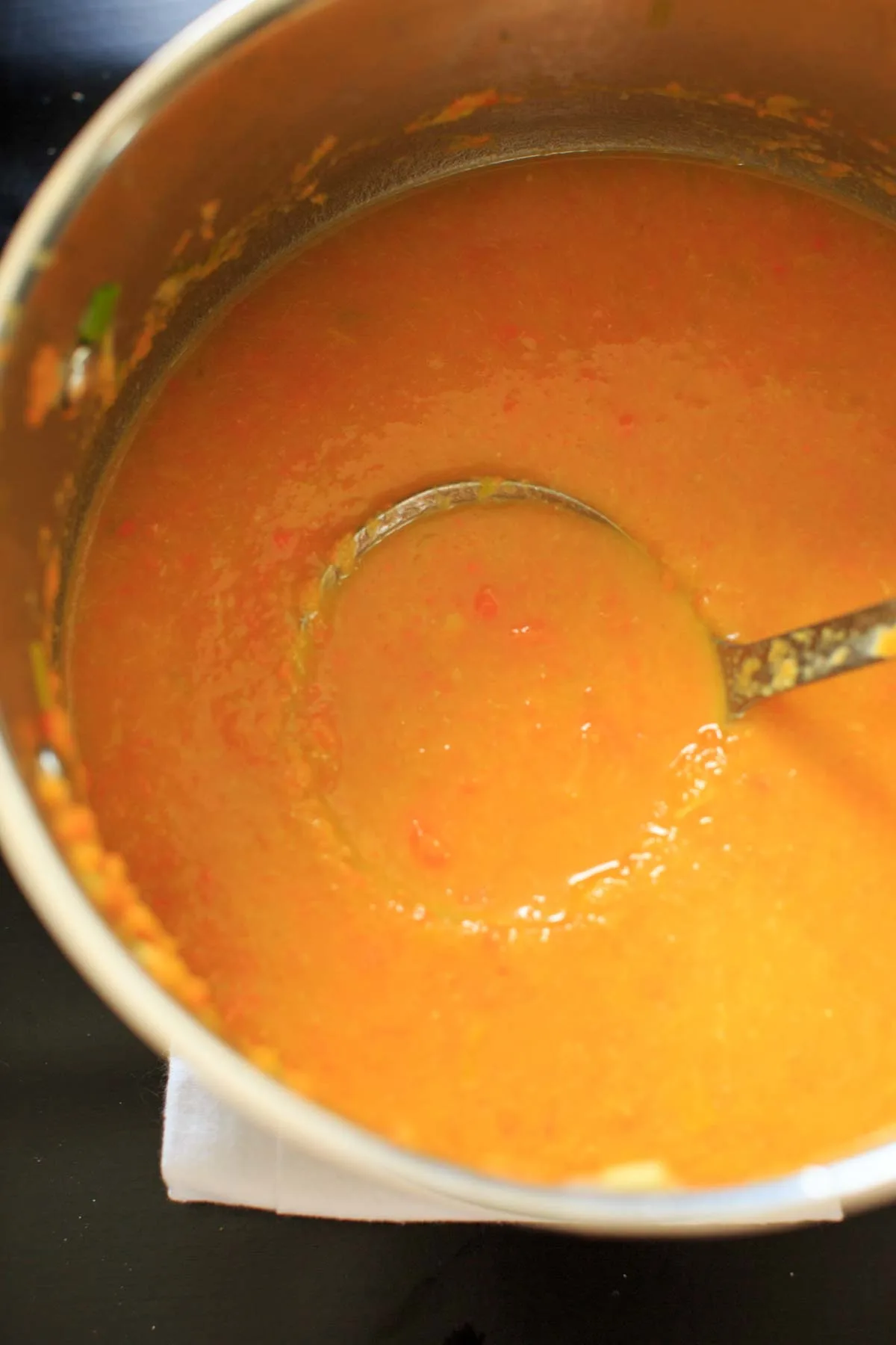 taking a spoonful of carrot leek soup from pot