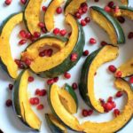 Roasted Acorn Squash with pomegranate seeds. An easy and beautiful side dish for any dinner table.