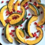 Roasted Acorn Squash with pomegranate seeds. An easy and beautiful side dish for any dinner table.
