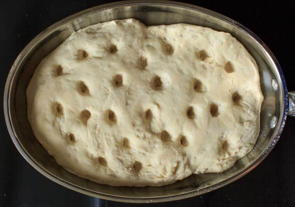 holes poked in focaccia bread dough